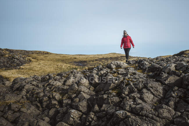 Mulher desfrutando paisagem cênica incrível da Irlanda do Norte durante a viagem enquanto caminhava em solo rochoso — Fotografia de Stock