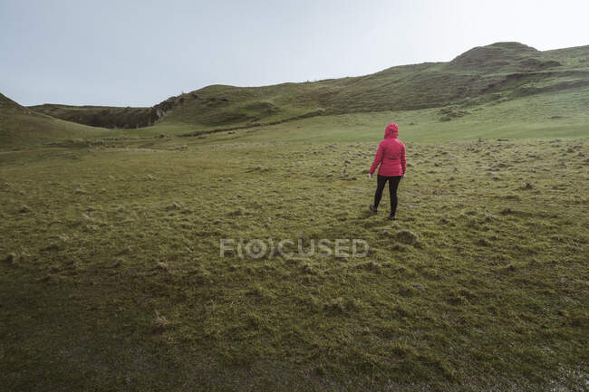 Donna anonima godendo incredibile paesaggio panoramico dell'Irlanda del Nord durante il viaggio mentre si cammina su un terreno roccioso — Foto stock