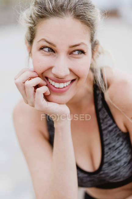 Content young looking away and smiling as touching face — Stock Photo