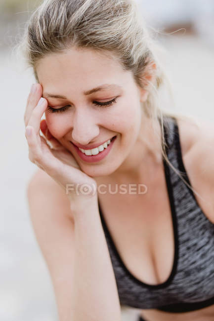 Content young with closed eyes smiling as touching face — Stock Photo