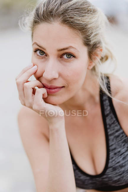 Content young female athlete looking in camera as touching face — Stock Photo