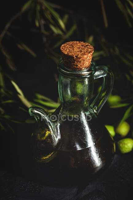 Свіжа іспанська додаткова діва оливкова олія з оливками і стара оливкова гілка на темному фоні Здорова їжа середземноморська їжа. Веган. Вегетаріанці — стокове фото