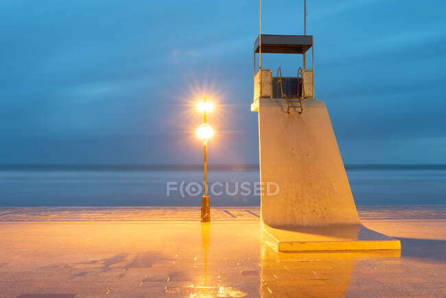 Torre solitaria de salvavidas en la playa al atardecer - foto de stock