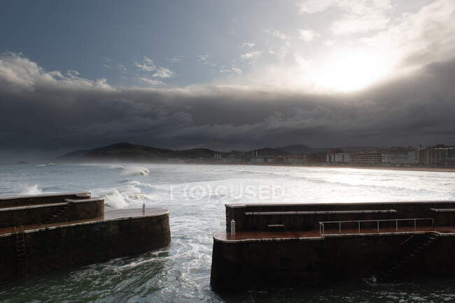 Quebra-mar rochoso com mar furioso em tempo nublado — Fotografia de Stock