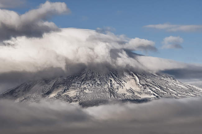Montagne rocciose nella foschia ricoperte di neve al caldo sole a Tortel, Cile — Foto stock