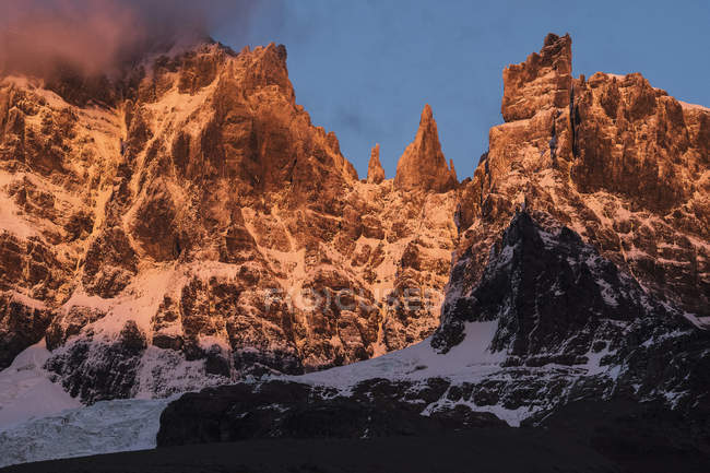 Montanhas rochosas em neblina cobertas de neve sob luz solar quente em Tortel, Chile — Fotografia de Stock