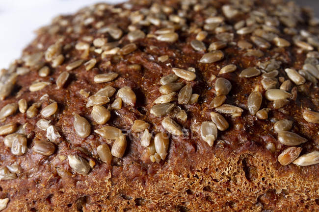 Loaf of grainy organic bread with seeds, close-up — Stock Photo