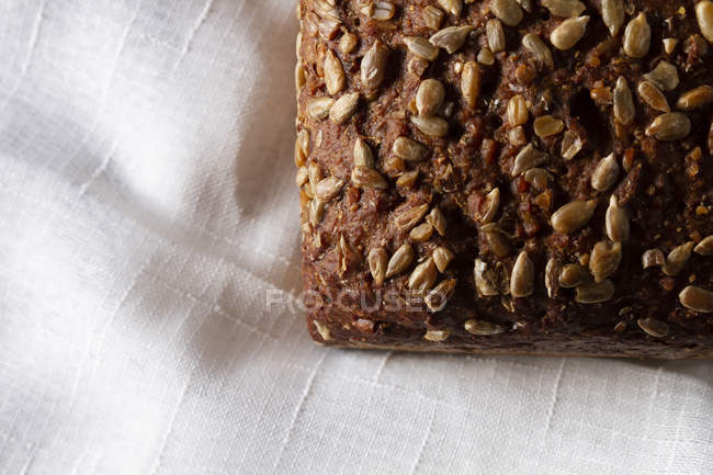 Pão orgânico granulado com sementes em toalha branca — Fotografia de Stock
