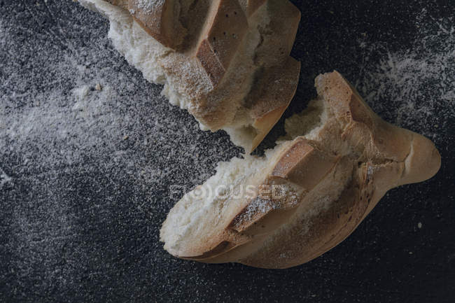 Буханка хлеба с надрезом на сером фоне — стоковое фото