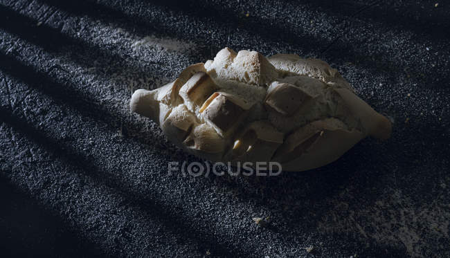 Loaf of bread with incisions on grey background — Stock Photo