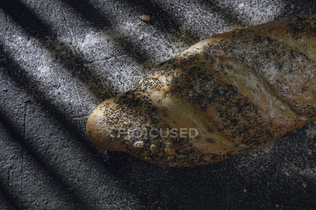 Хліб з зернами і маком на сірому фоні з тіні — стокове фото