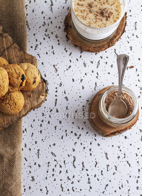 Composition de biscuits maison bio avec pot de poudre de cacao et verre de boisson de cacao savoureuse — Photo de stock