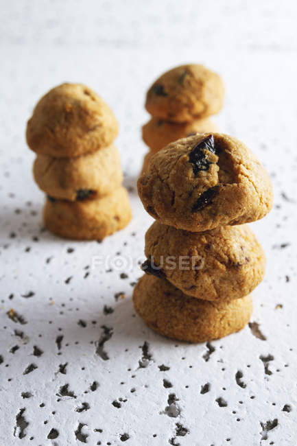 Stacks of fresh homemade brown cookies with chocolate on white table — Stock Photo