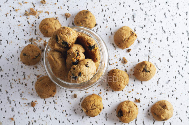 High angle of  jar of fresh homemade brown cookies with chocolate on white table — Stock Photo