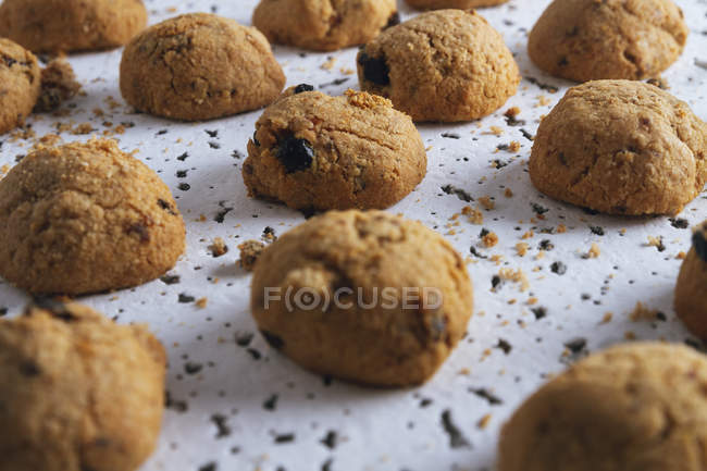 Angolo alto di biscotti marroni freschi fatti in casa con cioccolato sul tavolo bianco — Foto stock
