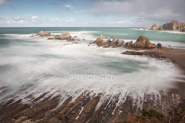Türkisfarbenes Wasser und unruhige weiße Schaumwellen am Strand von La Gueirua in Spanien — Stockfoto