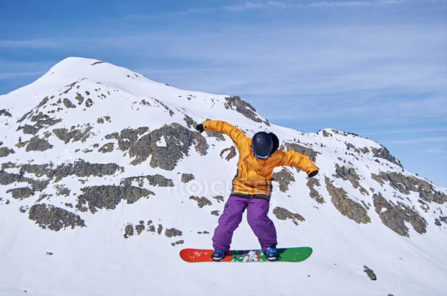 Unrecognizable snowboarder jumping on slope — Stock Photo