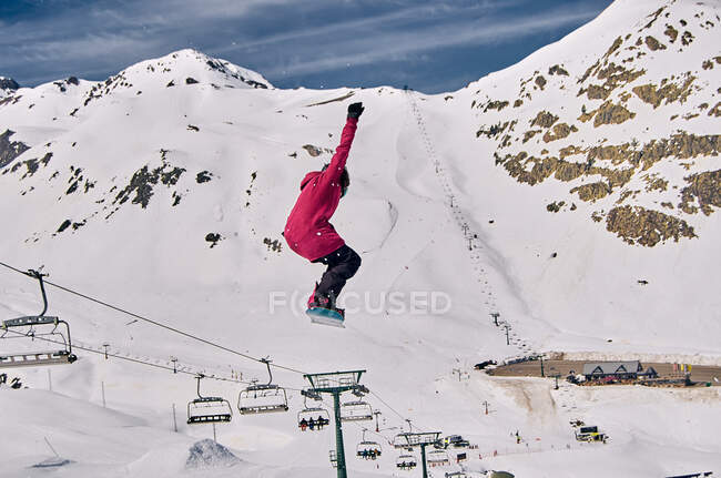 Snowboarder irreconocible saltando en la pendiente - foto de stock