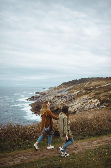 Glückliche Freundinnen auf Wanderschaft am Meer — Stockfoto