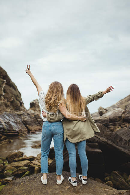 Jovens irmãs em pé na pedra no dia da primavera — Fotografia de Stock