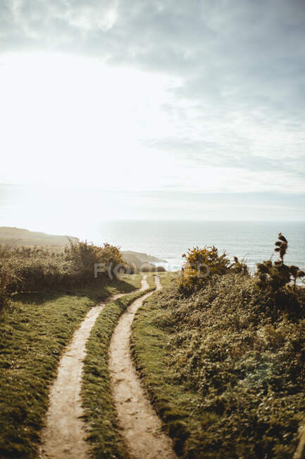 Estrada rut que conduz à beira-mar ao sol — Fotografia de Stock