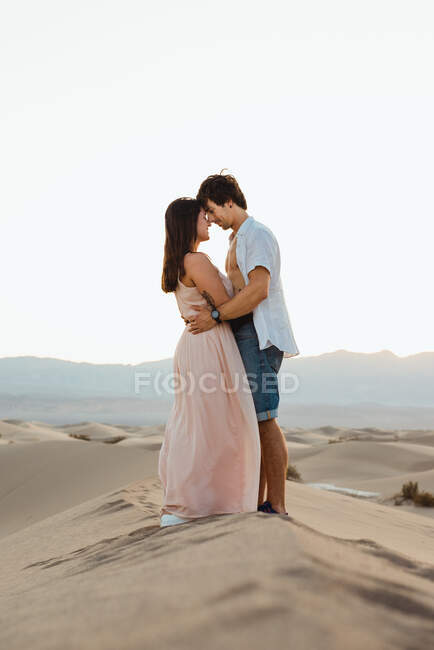 Tender casal abraçando no vale do deserto arenoso — Fotografia de Stock