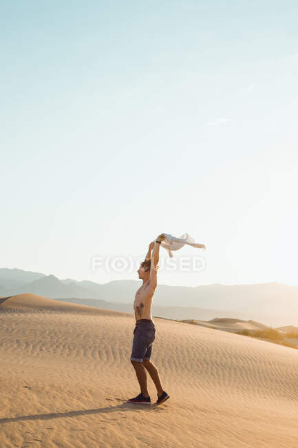 Вид збоку активного молодого чоловіка без сорочки, насолоджуючись вітром у сухому — стокове фото