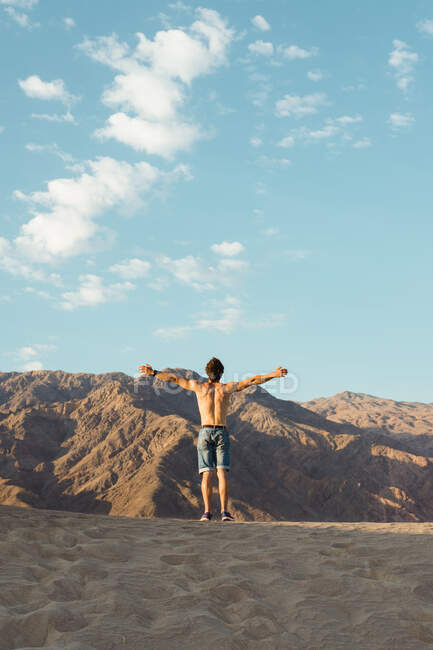 Rückenansicht eines aktiven jungen Mannes ohne Hemd, der Wind im Trockenen genießt — Stockfoto
