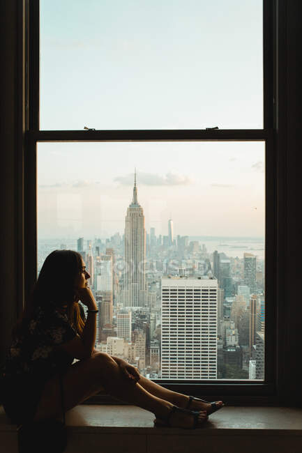 Mujer melancólica mirando por la ventana - foto de stock