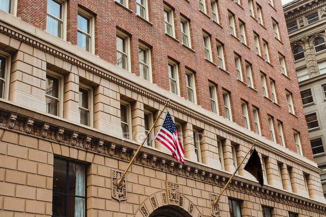 Bandeira americana pendurada na entrada de um edifício respeitável — Fotografia de Stock