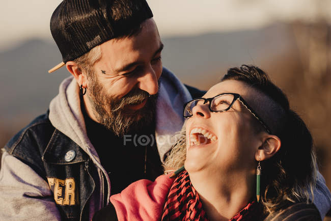 Laughing happy couple looking at each other on sunny weather — Stock Photo