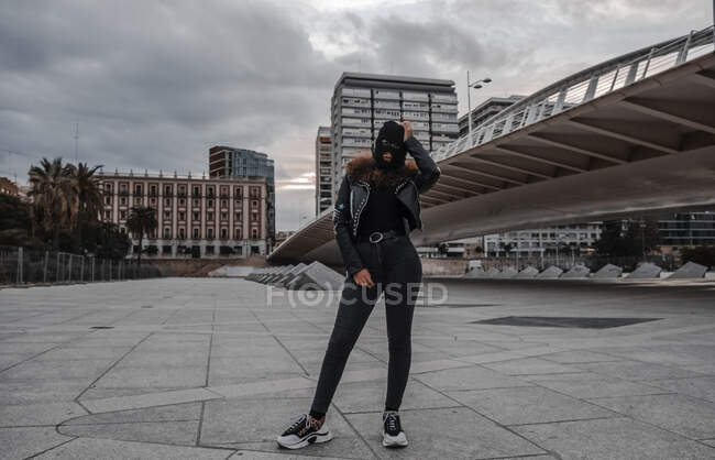 Mujer en pasamontañas y chaqueta de cuero negro - foto de stock