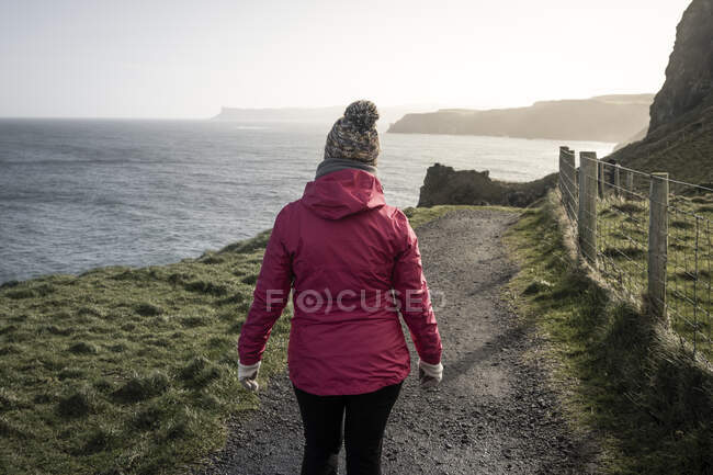 Mulher em pé na estrada do campo admirando vistas — Fotografia de Stock