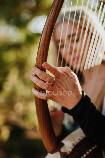 Romantische, charmante Frau mit blonden Haaren, die Melodie genießt, während sie Musikinstrument spielt und im Sommer im Garten sitzt — Stockfoto