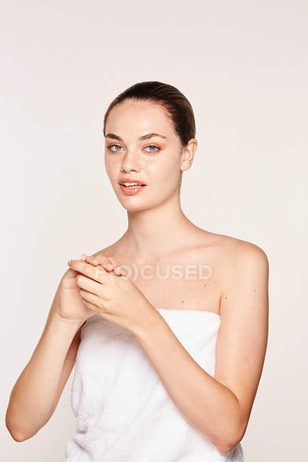 Mujer encantada aplicando crema de recuperación en las manos - foto de stock