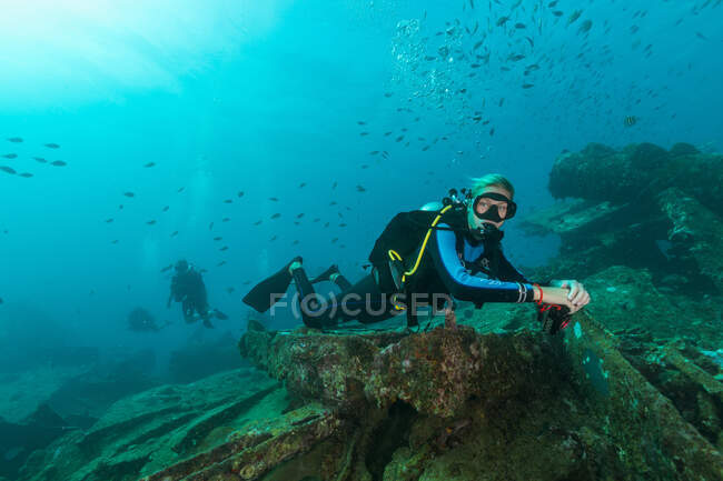 Immersioni subacquee nuotare sott'acqua esplorando relitti — Foto stock