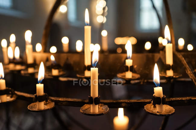 Chama dourada de velas em castiçais brilhando na escuridão na Catedral de Oslo — Fotografia de Stock
