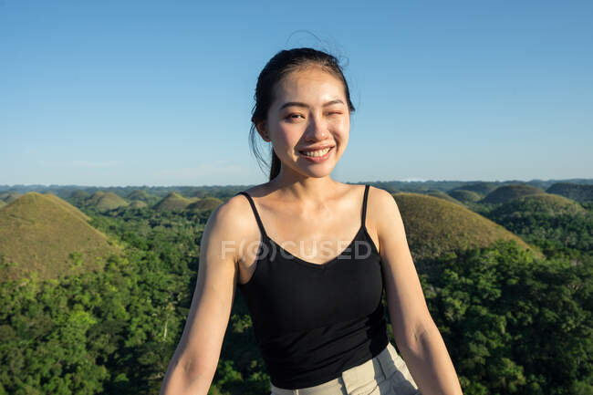 Happy woman standing on observation deck on hill — Stock Photo
