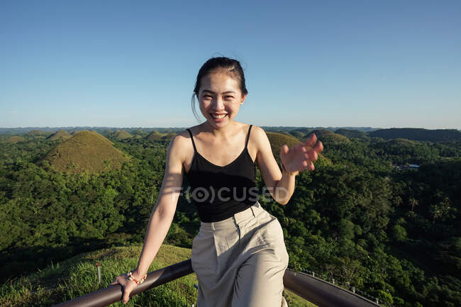 Mulher feliz em pé no deck de observação na colina — Fotografia de Stock