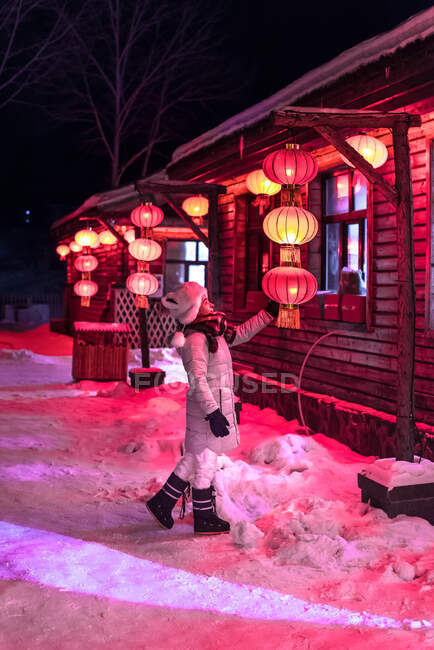 Jovem mulher examinando lanterna chinesa na casa — Fotografia de Stock