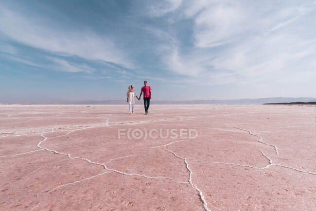 Glücklich entspannte Reisende genießen ungewöhnliche Landschaft des rosa Salzsees bei sonnigem Tag — Stockfoto