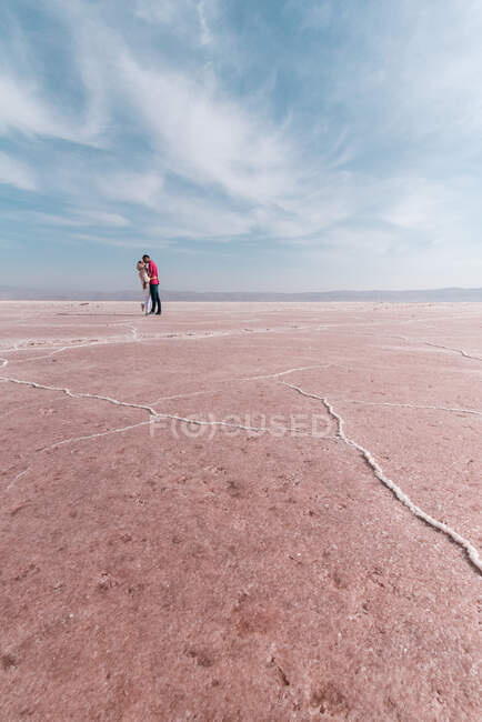Felices viajeros relajados disfrutando de paisajes inusuales de lago de sal rosa en un día soleado - foto de stock
