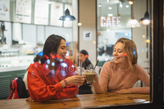 Багатоетнічні друзі розмовляють в кафе — стокове фото