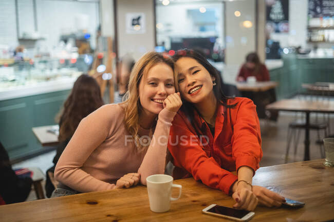 Багатоетнічні друзі розмовляють в кафе — стокове фото