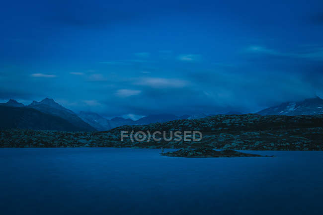 Удивительный пейзаж спокойной воды в холодном голубом свете с горным хребтом в Швейцарии — стоковое фото
