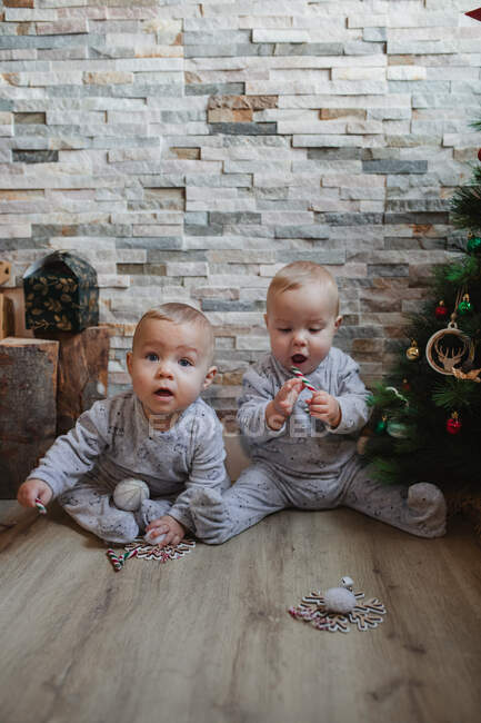 Babys begutachten Weihnachtsgeschenke zu Hause — Stockfoto