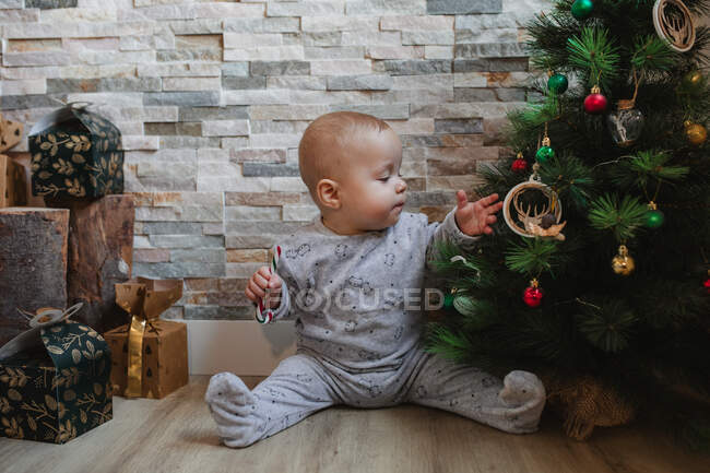 Cute baby playing with Christmas tree baubles — surprise, eve - Stock Photo  | #323362556