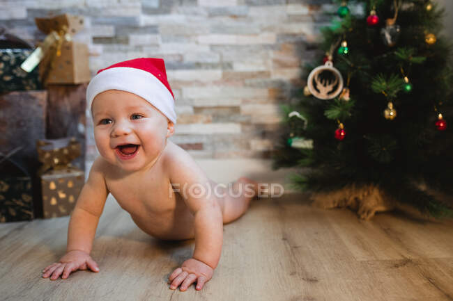 Bebê feliz deitado perto da árvore de Natal — Fotografia de Stock