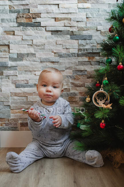 Мила дитина грає з різдвяними ялинками — стокове фото