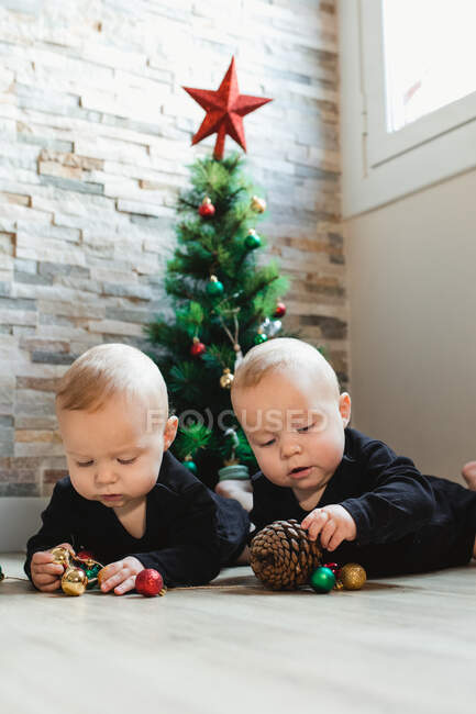 Gêmeos no chão perto da árvore de Natal — Fotografia de Stock